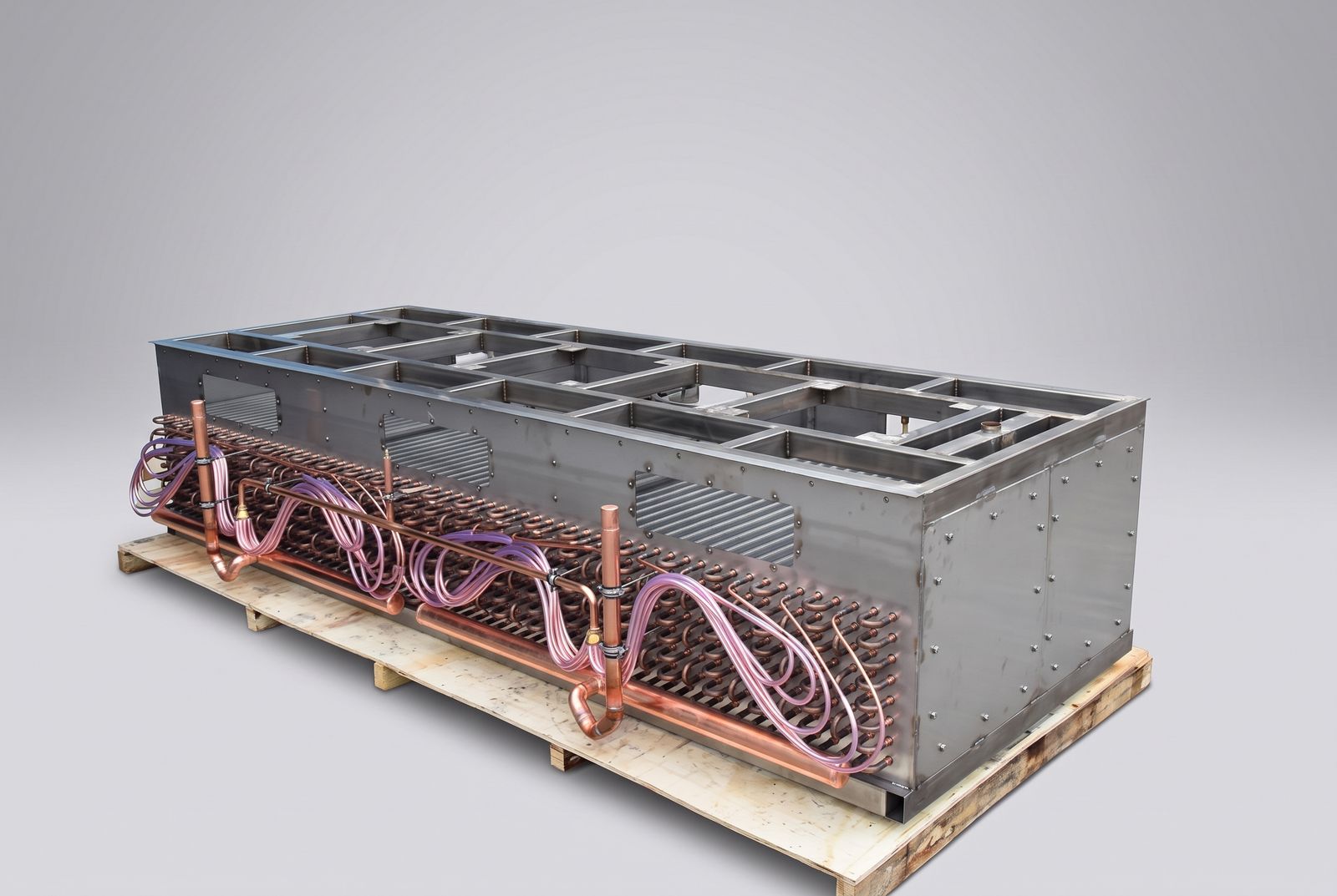 Stainless unit cooler shown before fan installation, with full copper coil circuiting and distributor lines exposed.