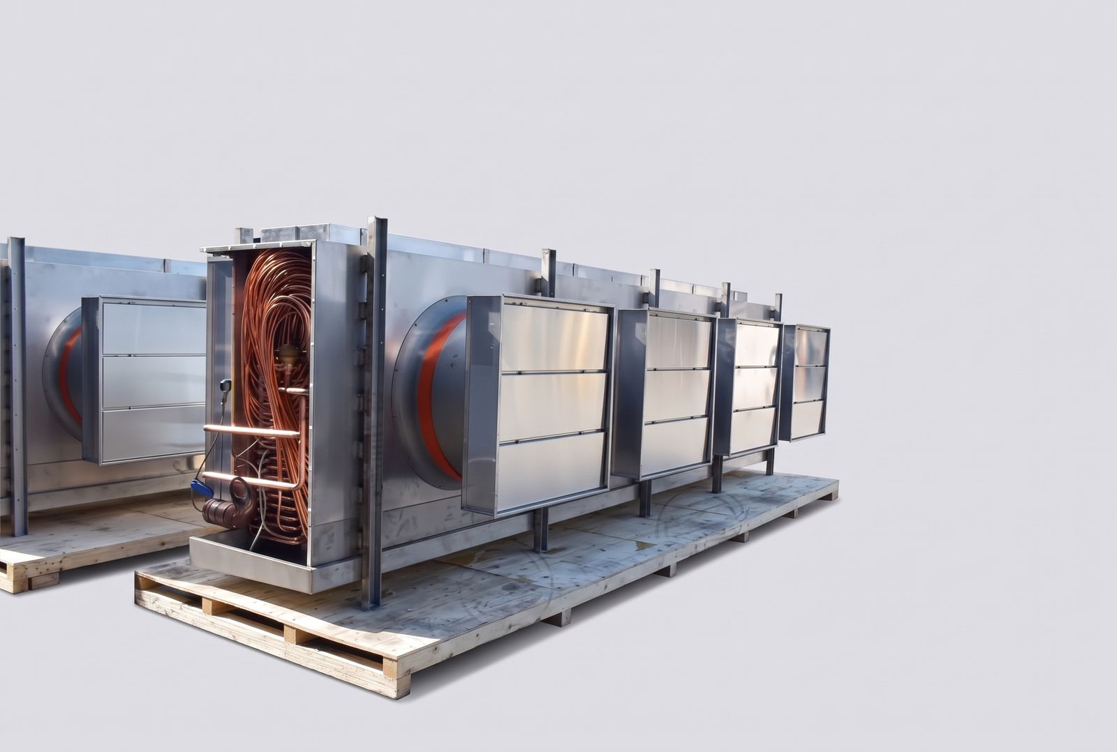 Long stainless steel unit cooler with exposed copper circuiting at the open end and hinged stainless access panels.