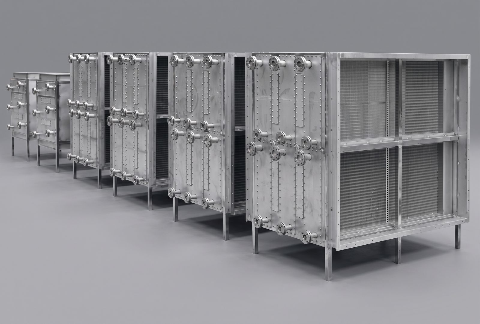 Row of all stainless heat exchanger sections with riveted stainless header covers and three columns of flanged connections each.